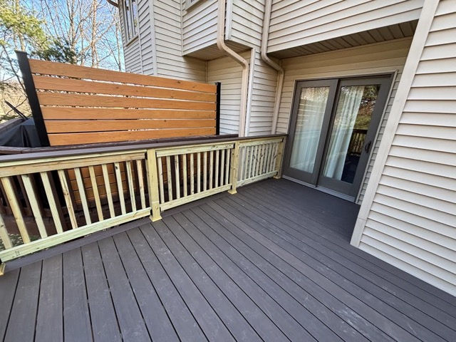 Low-maintenance composite deck installed on a Maryland home overlooking wooded backyard landscape