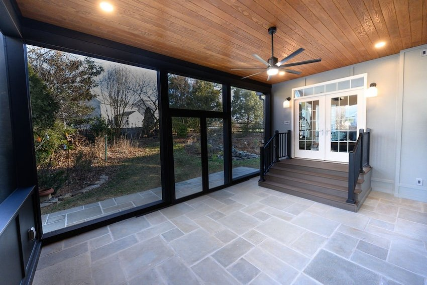 Custom screened porch in Columbia, Maryland with large screen panels, stone flooring, and TimberTech Mocha stair balcony.